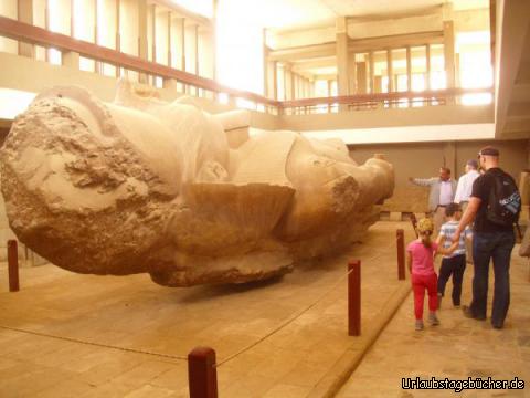 wir und der Koloss: Vivian, Viktor und ich neben der liegenden Kolossalstatue von Ramses II.
im Museumsgebäude des Freilichtmuseums von Memphis,
während unser Reiseführer Mohammed uns mit Wissen füttert