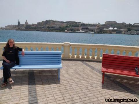 Ta' Xbiex: Katy auf einer Bank in der maltesischen Stadt Ta' Xbiex
vor dem Marsamxett Harbour und der Silhouette von Valetta im Hintergrund