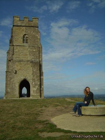 St Michaels: ich (schon wieder sitzend) auf dem Glastonbury Tor
und im Hintergrund die Ruine des Turms von St. Michael’s