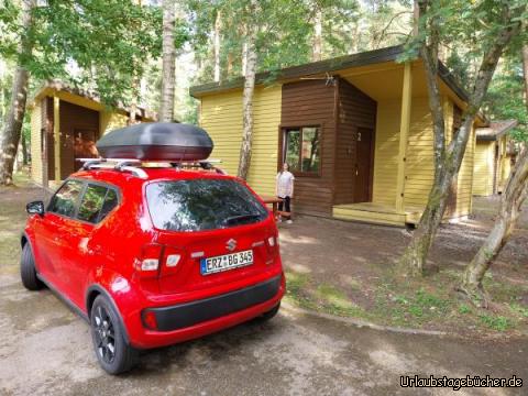 unser Bungalow: unser Auto und Vivian vor unserem Bungalow auf dem Pajūrio Kempingas von Klaipeda
