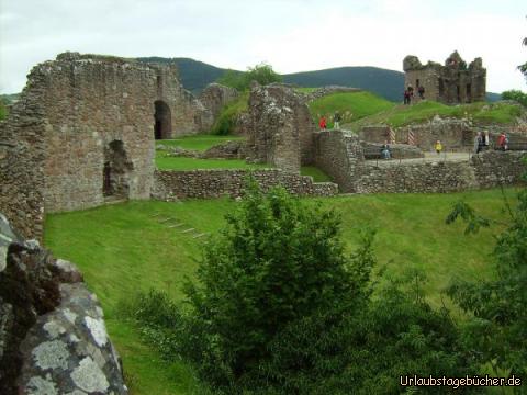 Katy im Urquhart Castle: ich auf einer Bank in der (ehemaligen) Großen Halle des Urquhart Castle
und schräg hinter mir sieht man das Tower house herausragen