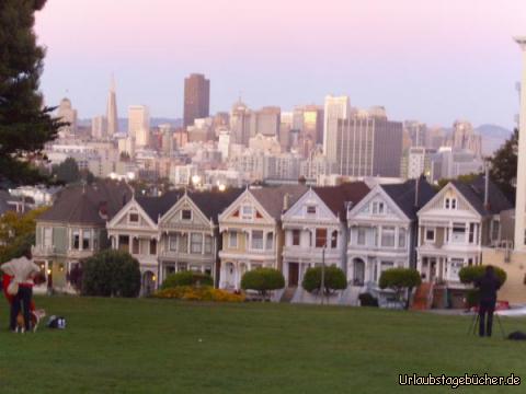 Painted Ladies: im Licht der untergehenden Sonne sehen wir die Painted Ladies:
viktorianische, mehrfarbig gestrichene Holzhäuser aus dem 19. Jh.
am Alamo Square in San Francisco vor der Skyline der Stadt
