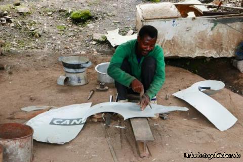 Blechner 2: Mit einem selbstgemachten Zirkel wird ein Kreis ins Blech geritzt und anschließend mit Hammer und Meisel ausgestanzt.