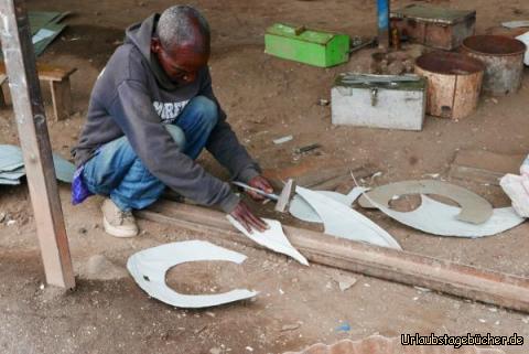 Blechner 4: Er fügt noch ein zweites Teil dazu, damit dann eine runde Form gemacht werden kann.