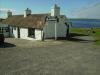 Last House: ich sitze hier neben dem Last House, dem letzten Haus Großbritanniens,
direkt neben dem Fähranleger von John o' Groats zu den Orkney Inseln (hinter mir)