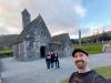 wir in Glendalough: vor Kevin's Kirche und dem Rundturm (im Hintergrund) in Glendalough